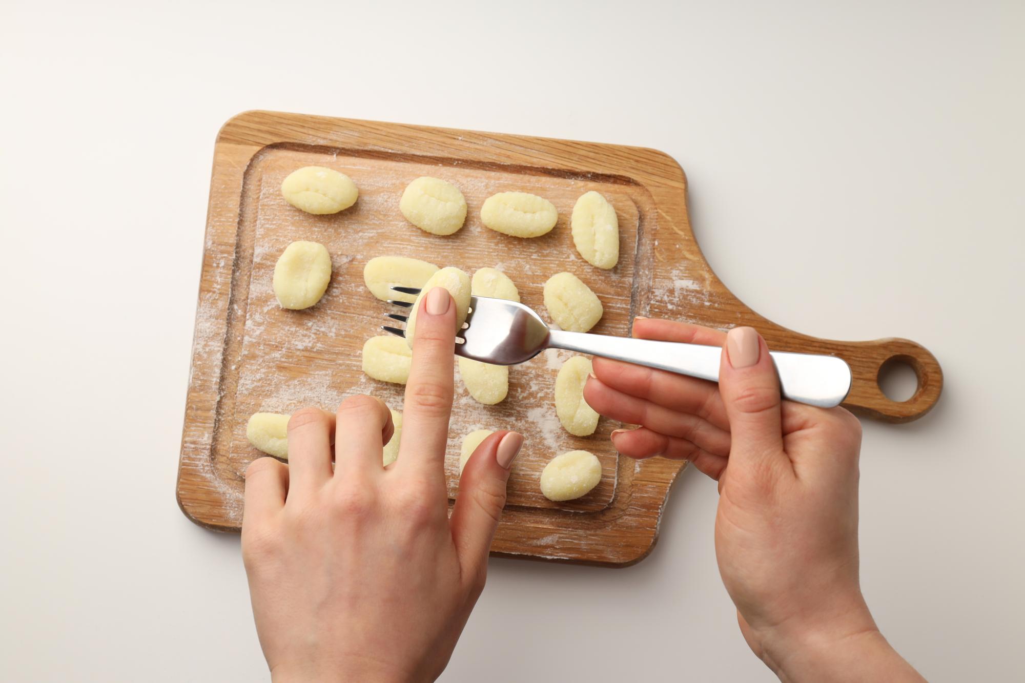 Zbliżenie na gotujące dłonie formujące gnocchi